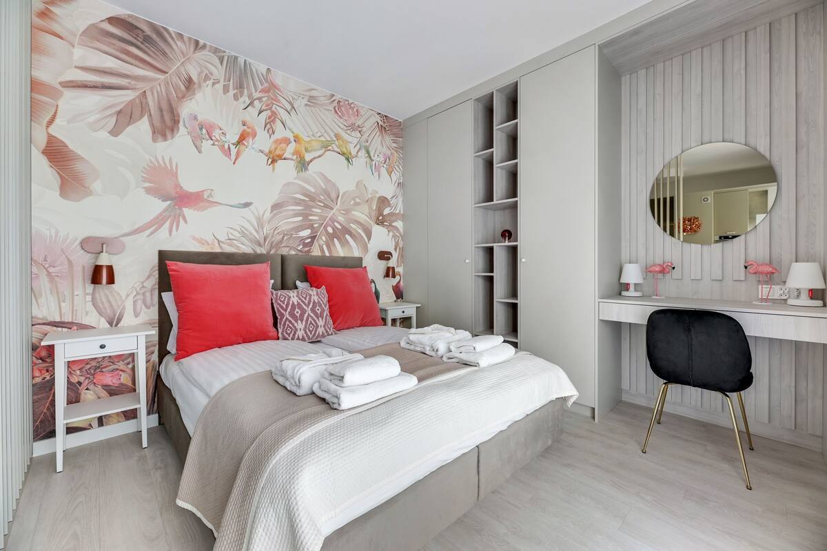 Une chambre à coucher comprenant un lit, des tables de chevet, un bureau, une chaise et une armoire.