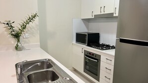 Una cucina moderna con elettrodomestici in acciaio inossidabile, un lavello doppio e mobili bianchi.