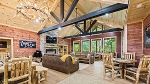 A rustic interior with wooden beams, a stone fireplace, and a cozy seating area. - Grand Overlook Resort | Luxury Pool Retreat (Broken Bow)