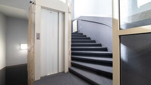 Una escalera con peldaños alfombrados que conduce a una puerta blanca.