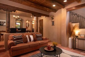 A living room with a brown leather sofa, a coffee table, and a fireplace.