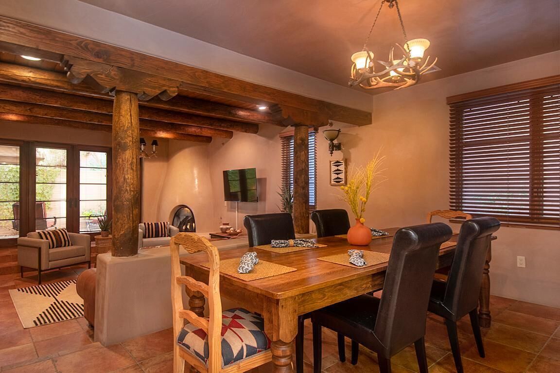 Un coin repas avec une table en bois, des chaises et un lustre.