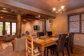 A dining area with a wooden table, chairs, and a chandelier.