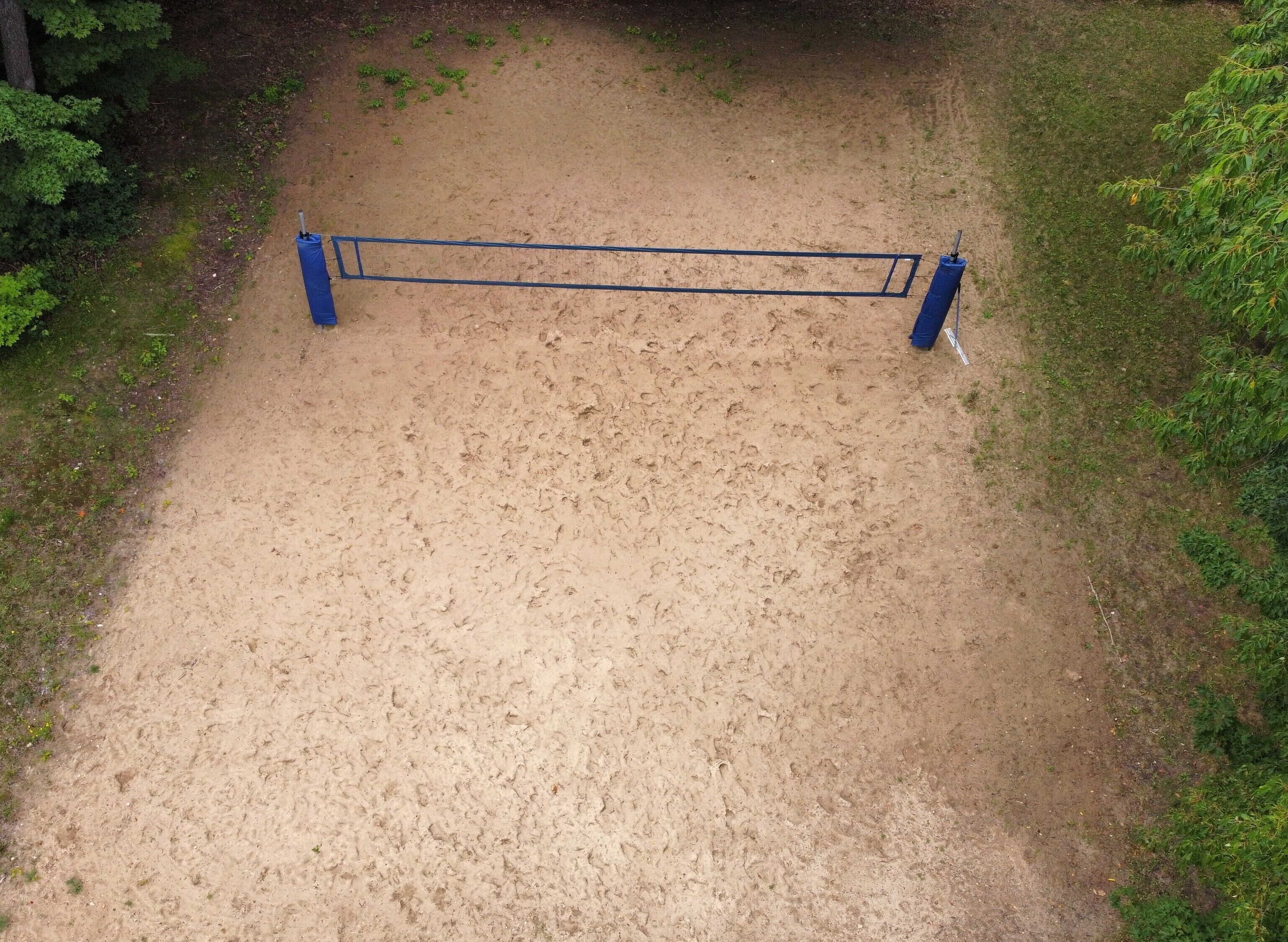 A sandy path with a blue metal barrier in the center.