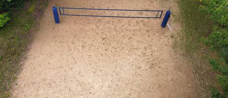 A sandy path with a blue metal barrier in the center.