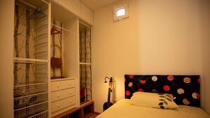 A bedroom with a bed, a wardrobe, and a small window. - Coqueto Apartamento a 5 Minutos del Retiro (Madrid)
