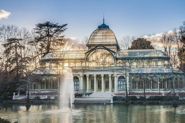 A large glass-domed building with a fountain in front, surrounded by trees. - Coqueto Apartamento a 5 Minutos del Retiro (Madrid)
