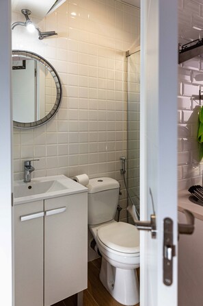 A bathroom with a white sink, toilet, and shower. - Coqueto Apartamento a 5 Minutos del Retiro (Madrid)