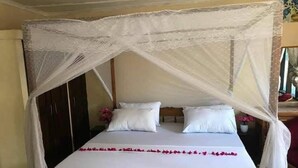 A bed with a canopy, white bedding, and a decorative border. - Charming and Remarkable15-bed Villa in Diani Beach (Diani Beach)