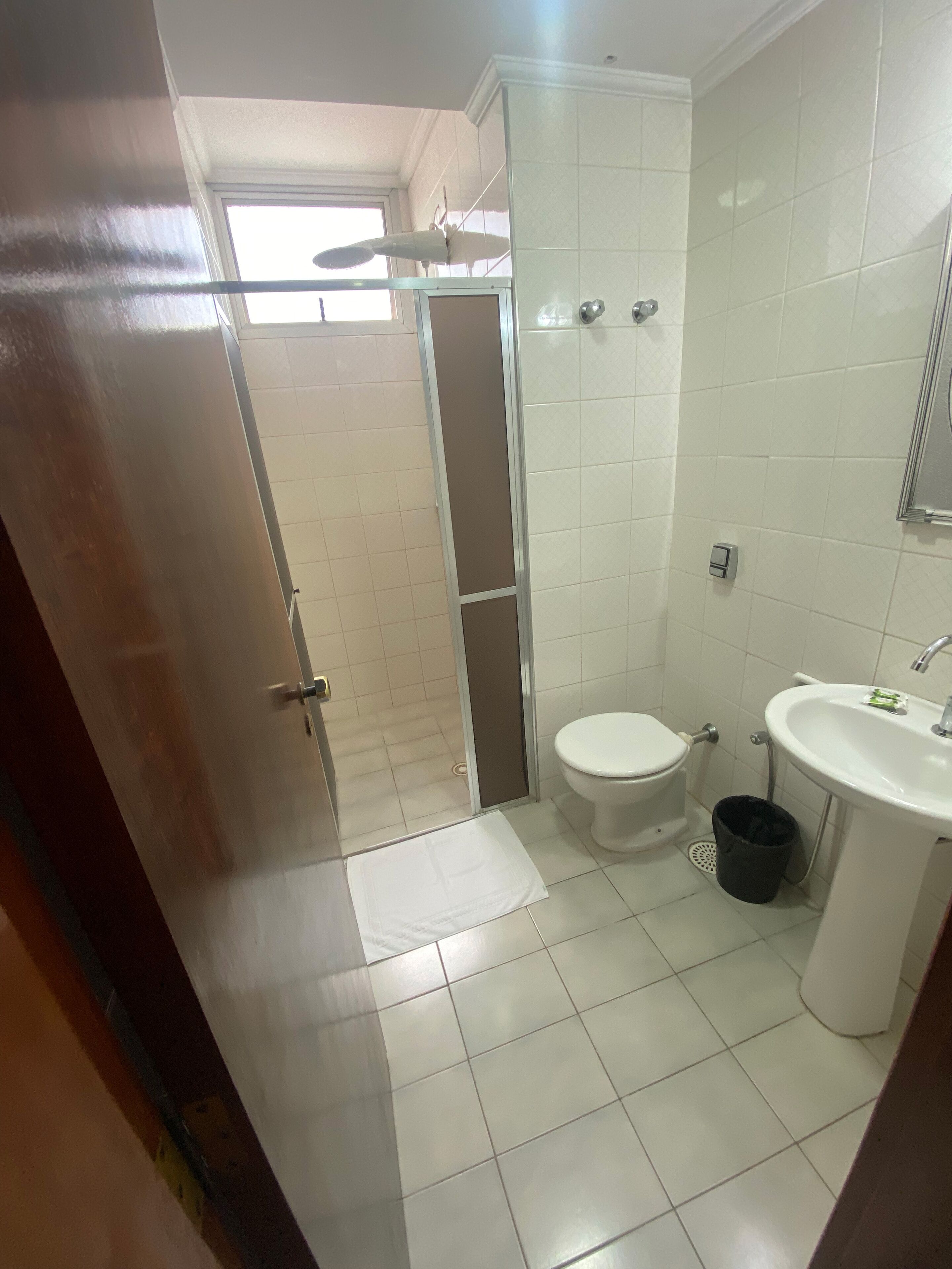 A bathroom with a toilet, sink, and shower.