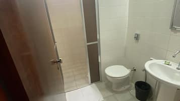 Un baño con inodoro, lavamanos y ducha.