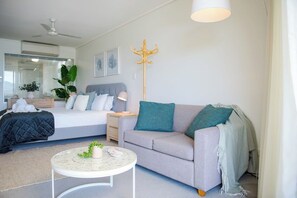 Ein modernes Wohnzimmer mit einem Bett, einer Couch und einem runden Couchtisch.