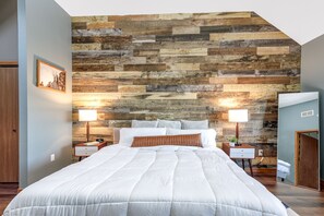 Relax in this serene bedroom with a large bed, bedside tables, and a framed picture.