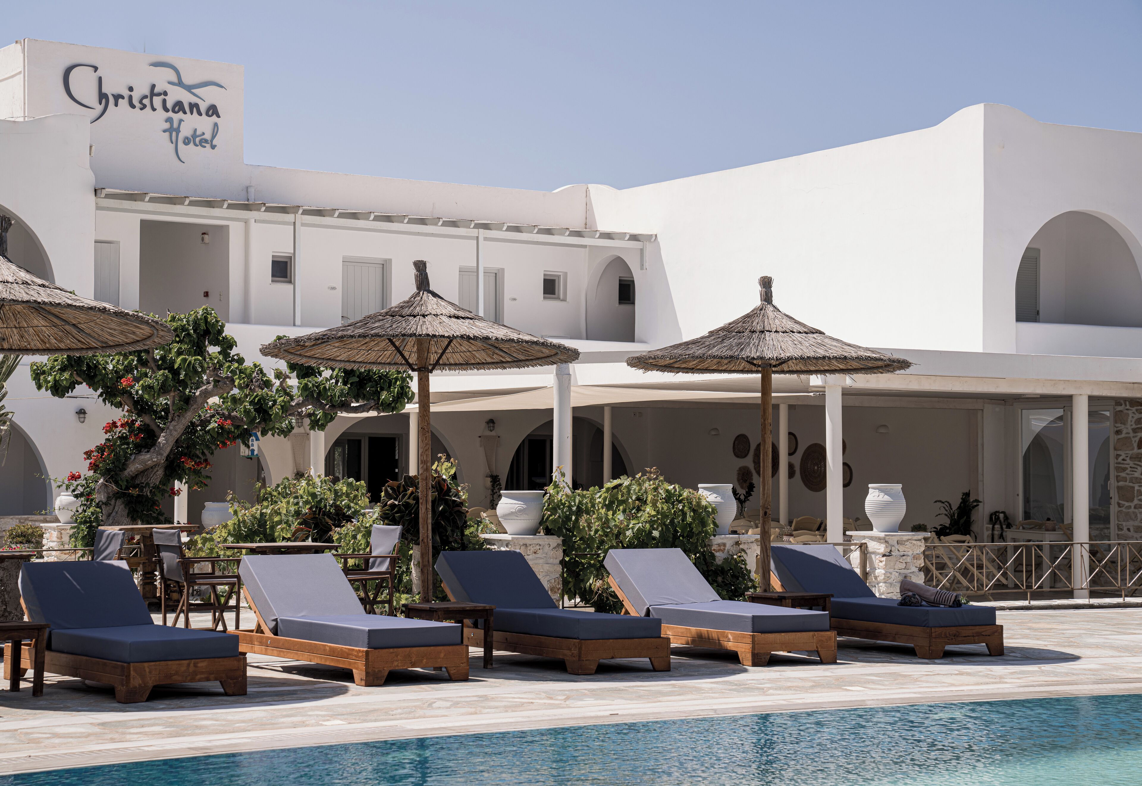 A poolside area with lounge chairs and umbrellas at the Christiana Hotel.