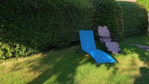 A grassy outdoor area with a blue lounge chair and a checkered lounge chair. - La Lisière du Morvan (Magny-Lormes)