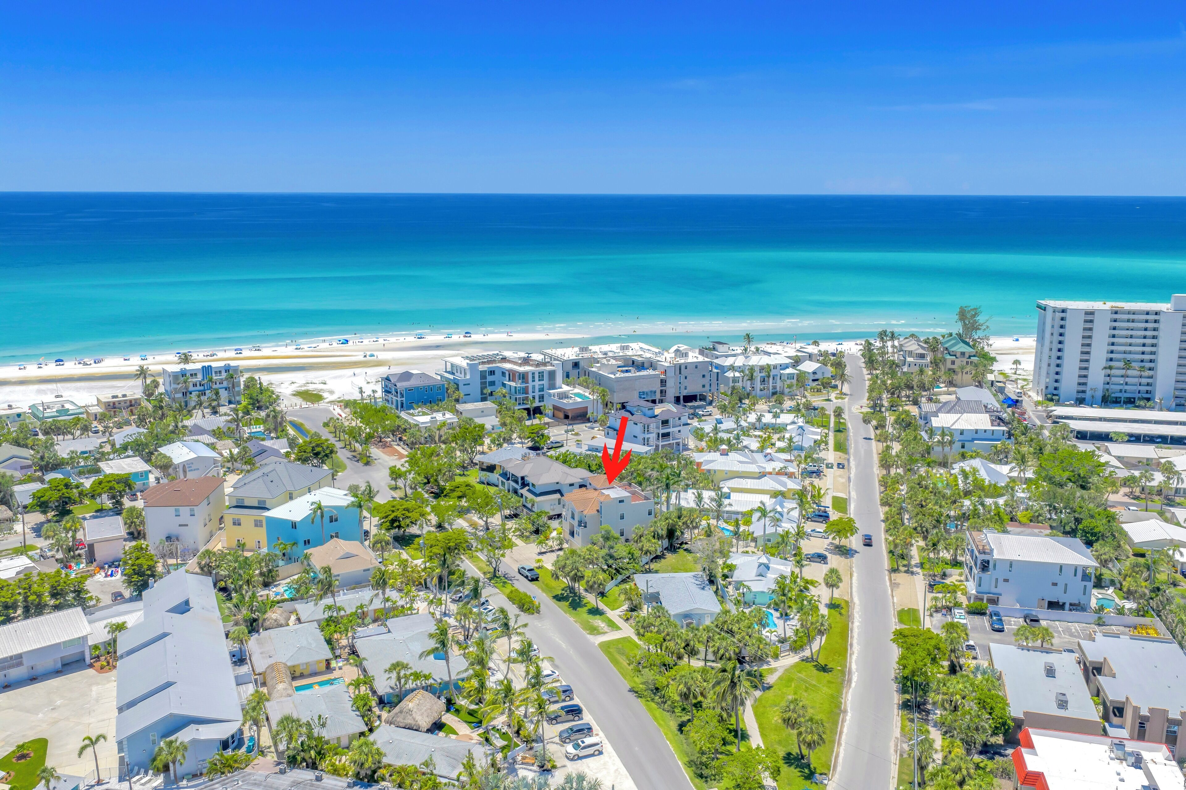 An aerial view of a coastal town with buildings, roads, and a beach.