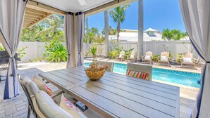 A patio with a pool, outdoor furniture, and a view of the pool area. - Gertrude's Siesta | 6 Terraces, Rooftop, Pool, 1-min to Beach and Village! (Siesta Key)