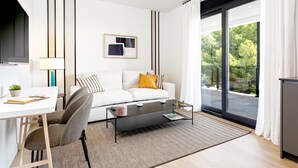 Een moderne woonkamer met een witte bank, een zwarte salontafel en een glazen deur naar een balkon.