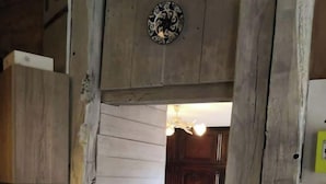 Eine rustikale Küche mit Holzwänden, einer weißen Arbeitsplatte und einer Holztür zu einem anderen Raum.