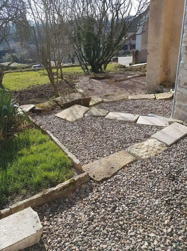Un sentier de jardin agrémenté de pas japonais, de gravier et de gazon.