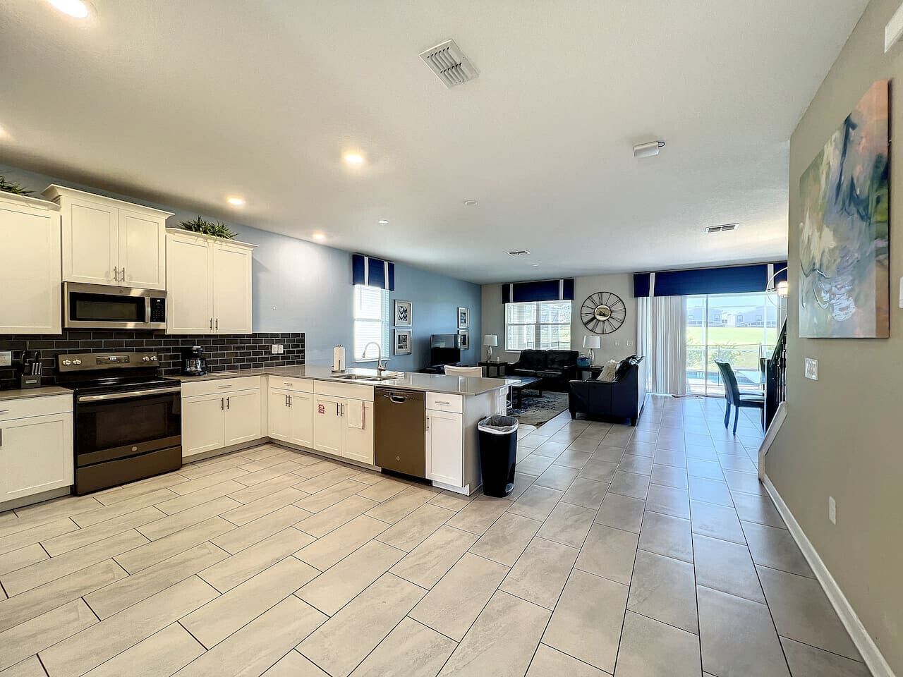 A spacious kitchen with a central island, built-in appliances, and a view to the living area.