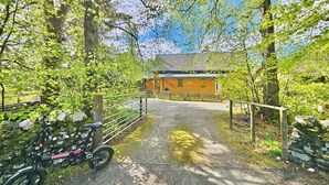 A gravel path leading to a wooden building with a metal gate.