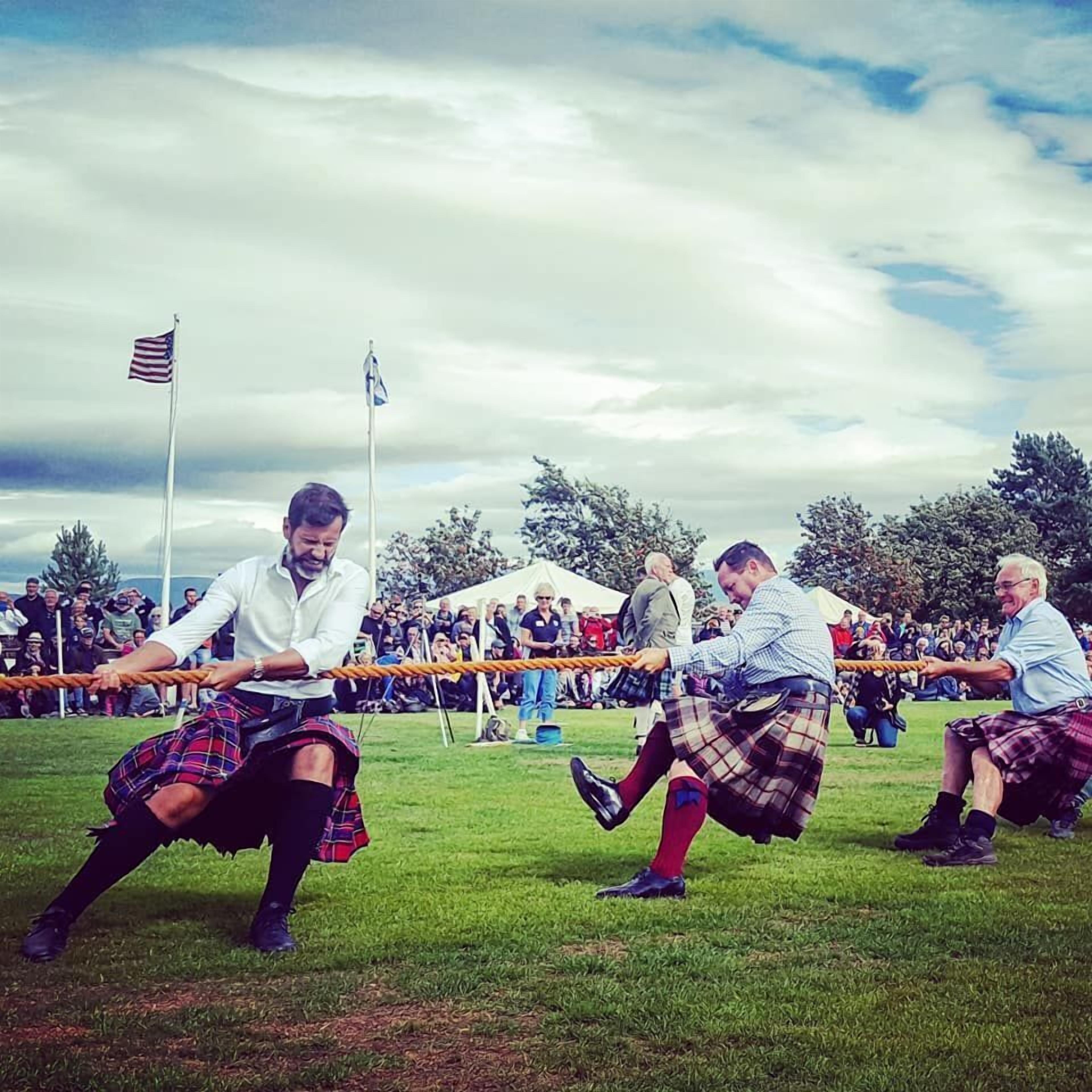 A group of people in kilts participating in a tug-of-war event.