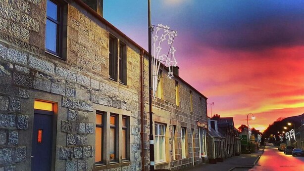 Un bâtiment en pierre avec un lampadaire et un drapeau.