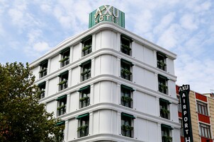 Un hotel de varios pisos con un letrero llamativo que dice "AXU AIRPORT HOTEL".