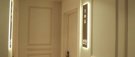 A hotel room entrance with a door marked "105" and a sign indicating "AXU HOTEL".