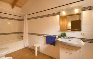 Een bad/douchecombinatie, een haardroger, een bidet, handdoeken