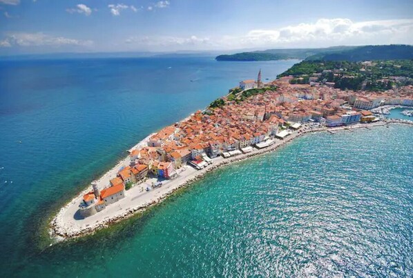 Experience the charm of a historic coastal town with red-tiled roofs and a picturesque waterfront setting.