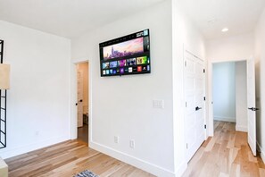 Ein modernes Interieur mit einem an der Wand montierten Smart-TV, der verschiedene Streaming-Dienste anzeigt.