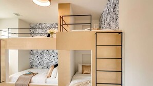 A bunk bed room with a ladder, a bedside table, and a wall with a comic-style pattern. - Nashville music-themed house sleeps 10 near Belmont Mansion (Nashville)