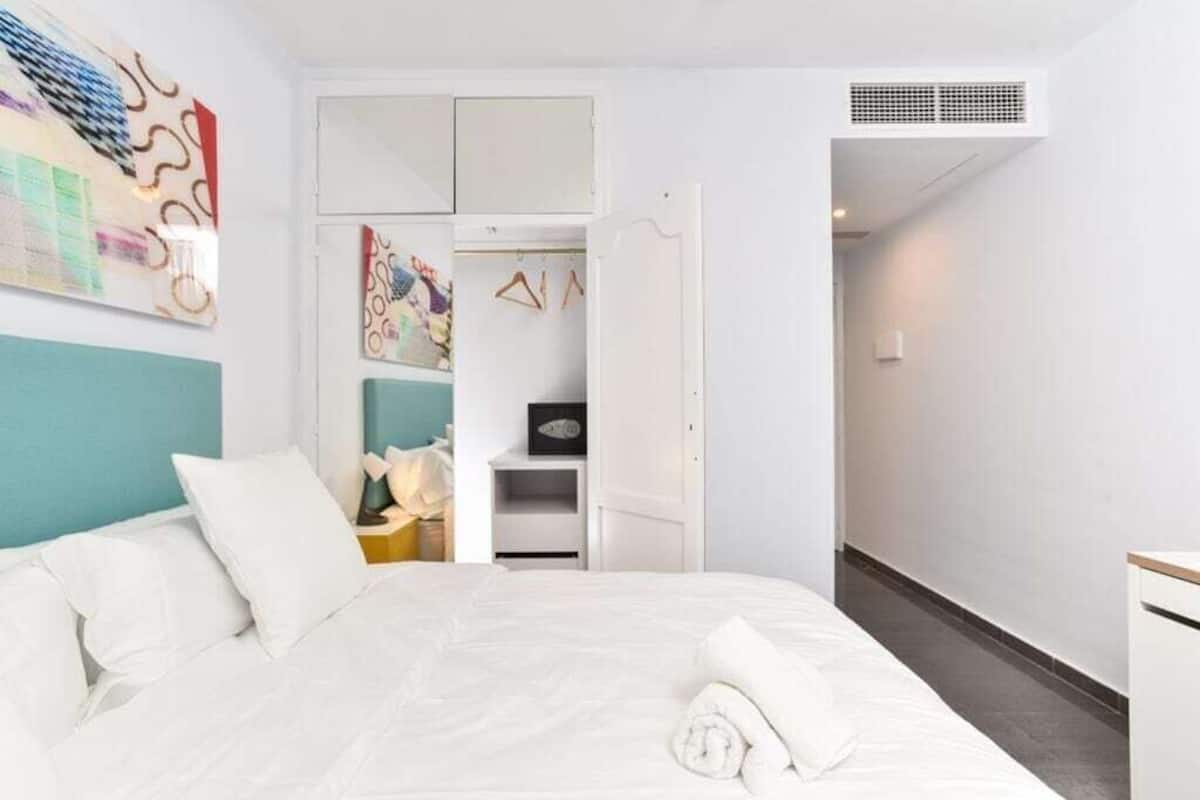Une chambre d’hôtel avec un lit, une armoire et un couloir.