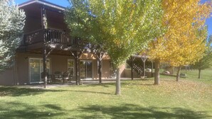 A two-story building with a covered patio area, outdoor seating, and a staircase leading to an upper level.