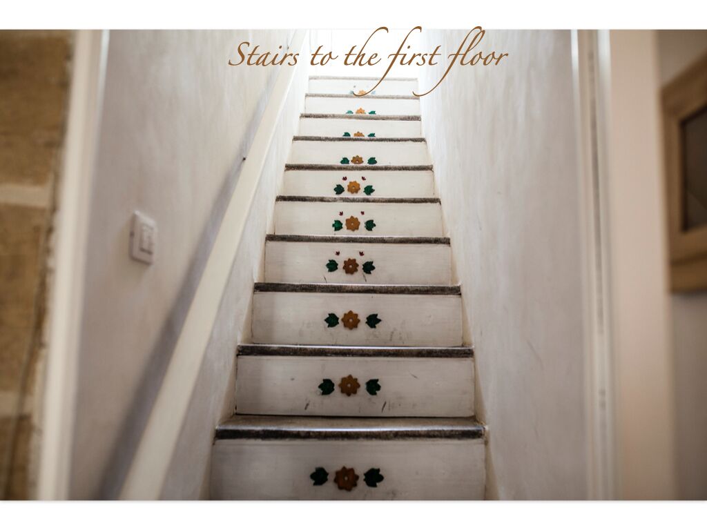 A staircase with decorative floral patterns leading to the first floor.