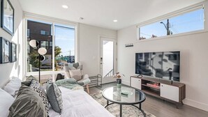 A modern living room with a sofa, coffee table, and TV. - Perch - Dayton Dream: Cozy and Modern Home | Parking and City View (Seattle)