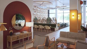 Een modern interieur met een houten console, een ronde spiegel, een bank en een eethoek met stoelen en tafels.