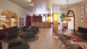 Een moderne lobby met groene zitplaatsen, een receptiebalie en een plant.