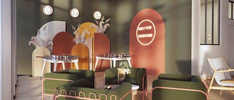 A modern lounge area with green upholstered sofas, a round table with a DJ setup, and a neon sign reading "ONLY FOR EVERYONE".