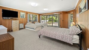 A bedroom with a bed, a dresser, a television, and a window with a view of the outdoors. - 22 Golf Links Road (Anglesea)