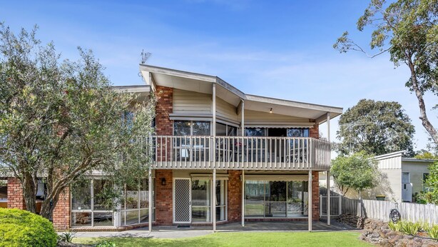 A two-story house with a balcony, large windows, and a well-maintained lawn. - 22 Golf Links Road (Anglesea)