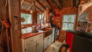 Una cucina rustica con travi in legno, un fornello e un lavello.
