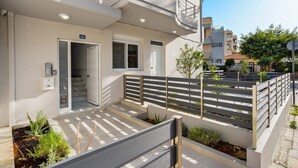 Un immeuble d’appartements moderne doté d’un balcon, d’un clavier à code pour l’accès et d’une porte portant le numéro 121.