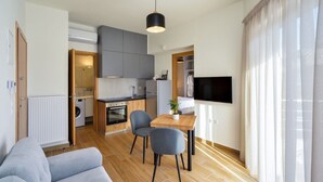 Un appartement moderne comprenant une cuisine, un coin repas et un salon.