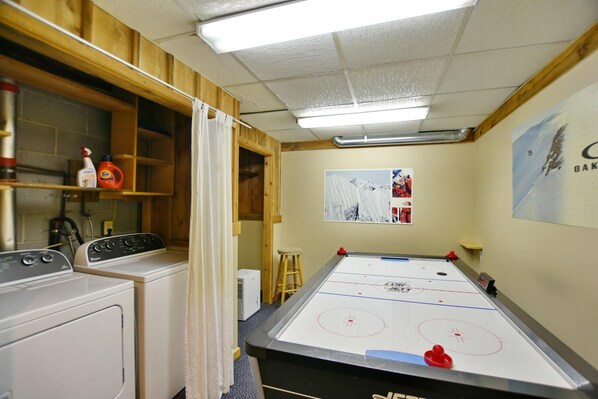 A room with a pool table, a washing machine, and a wooden cabinet with cleaning supplies. - Fully equipped Blue Mountain Chalet with outdoor hot tub (Town of the Blue Mountains)