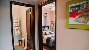 A bedroom with a bed, a bedside table, a lamp, and a framed picture on the wall.