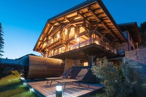 A wooden cabin with a balcony, a deck, and a circular structure. - Chalet Prestige Le Spencer - Spa & panoramic view (Châtel)