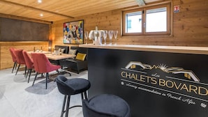 Ein gemütliches Interieur mit Barbereich, Sitzgelegenheiten und einem Gemälde an der Wand.